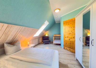 Schlafzimmer mit Kinderbett im Ferienhaus 2